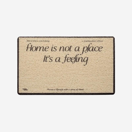 Ovimatto tekstillä "Home is a feeling"