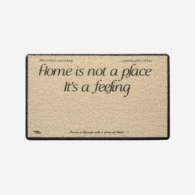 Ovimatto tekstillä "Home is a feeling"