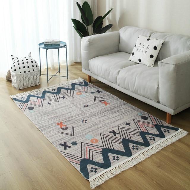 Harmaa design-matto oransseilla yksityiskohdilla